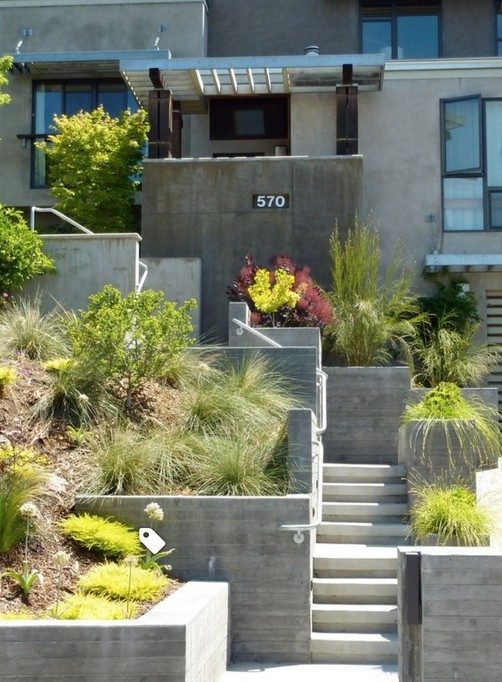 Terraced garden beds and a visible street number marking a private entry